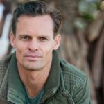 Close-up portrait of a man wearing a casual jacket outdoors.